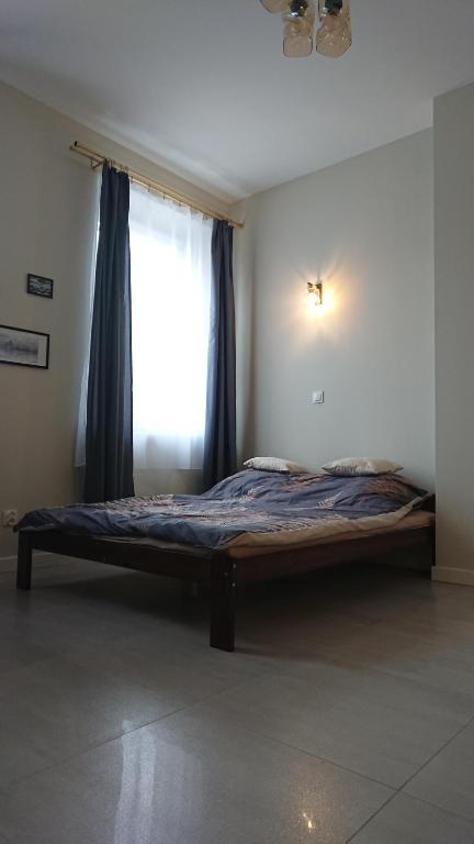 ein Bett in einem Zimmer mit einem Fenster in der Unterkunft Apartament Pod Semaforem Duszniki-Zdrój in Duszniki-Zdrój