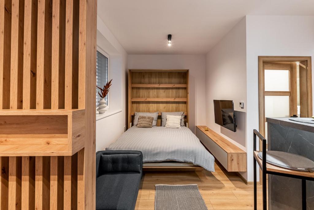 - une petite chambre avec un lit et une télévision dans l'établissement One bedroom apartment, à Dolný Kubín