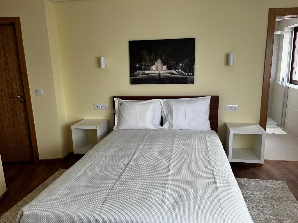 a bedroom with a large bed with two white pillows at Aliança Alojamento Local in Guarda