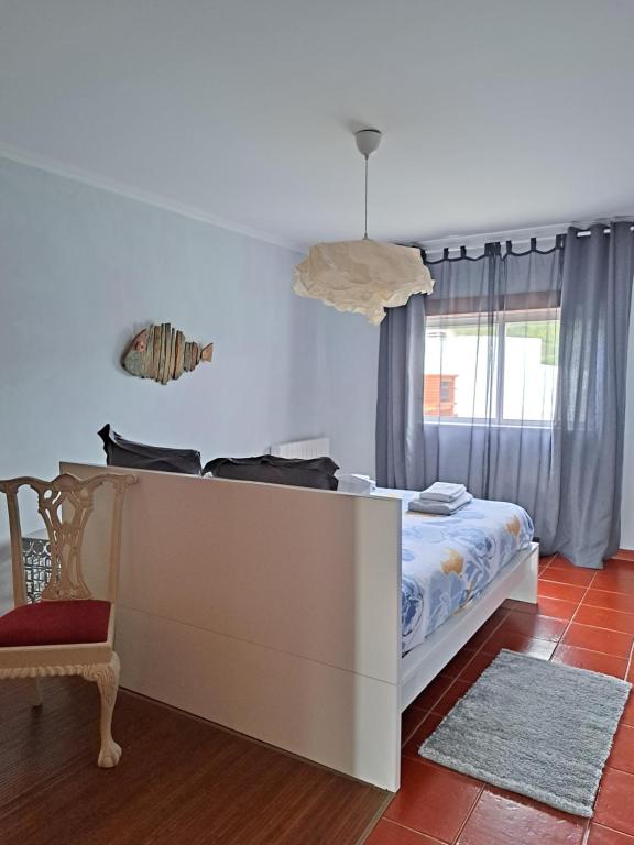 een slaapkamer met een bed en een raam bij Camarção Violante in Foz do Arelho