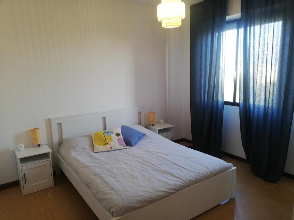 a bedroom with a bed with blue curtains and a window at Panorama in Milan