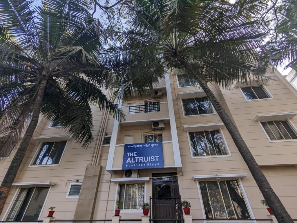 a building with palm trees in front of it at The Altruist Business Stays B-2 in Bangalore