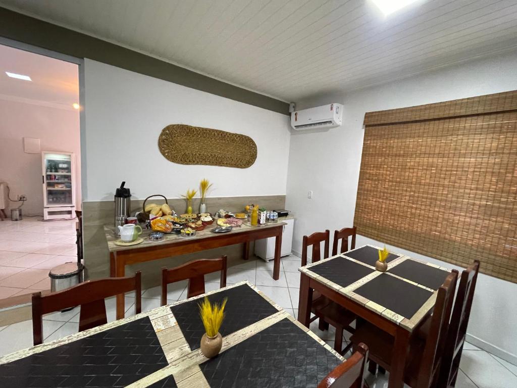 - une cuisine et une salle à manger avec une table et des chaises dans l'établissement Pousada Ventura, à Anchieta