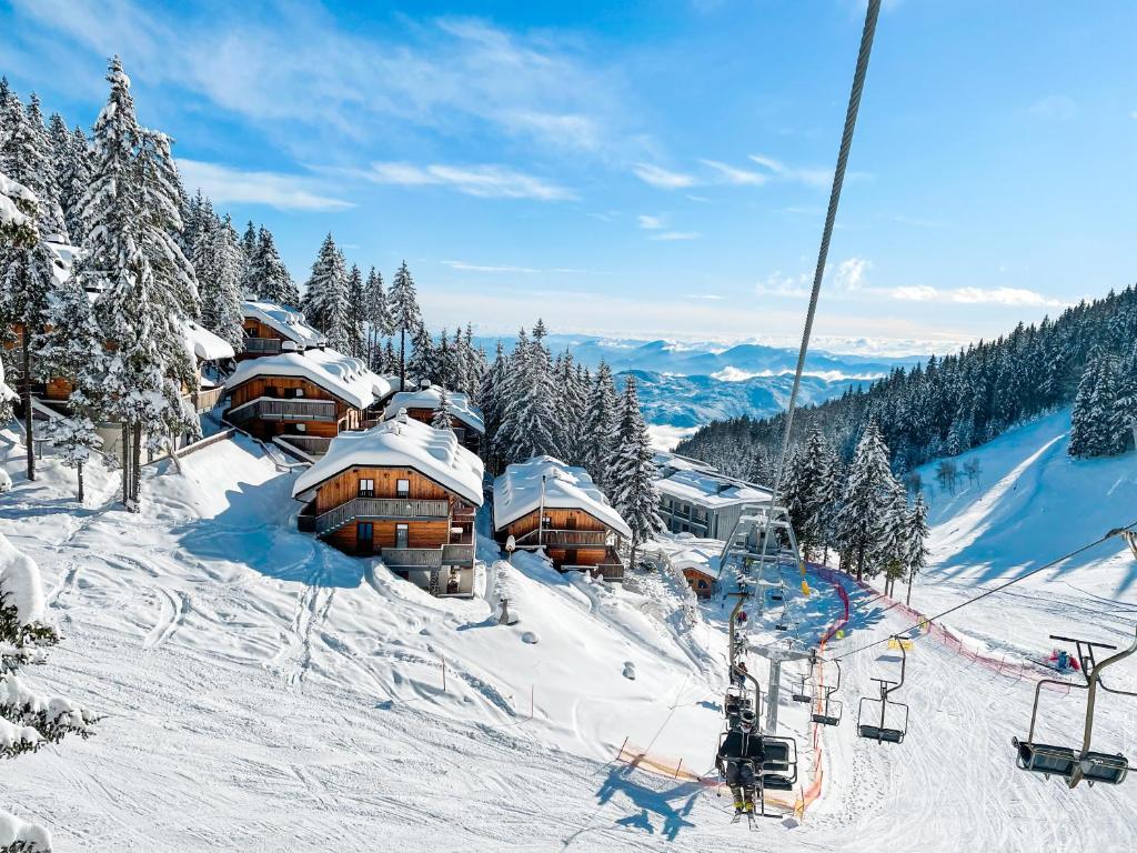 a ski lodge on a snowy mountain with a ski lift at Sunshine Apartments Golte C1 in Mozirje