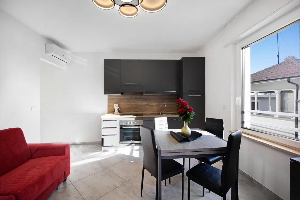 una cucina e una sala da pranzo con tavolo e divano rosso di Sanremo casa vista mare a Sanremo