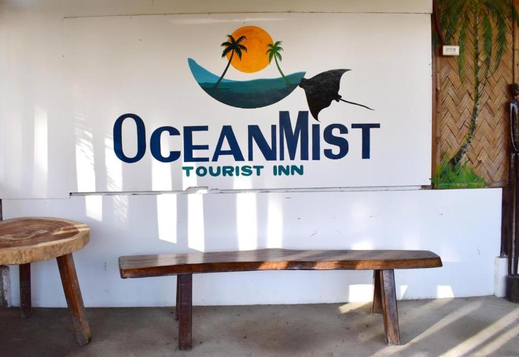a sign for an ocean must tourist inn with a bench at Ocean Mist Tourist Inn in San Vicente
