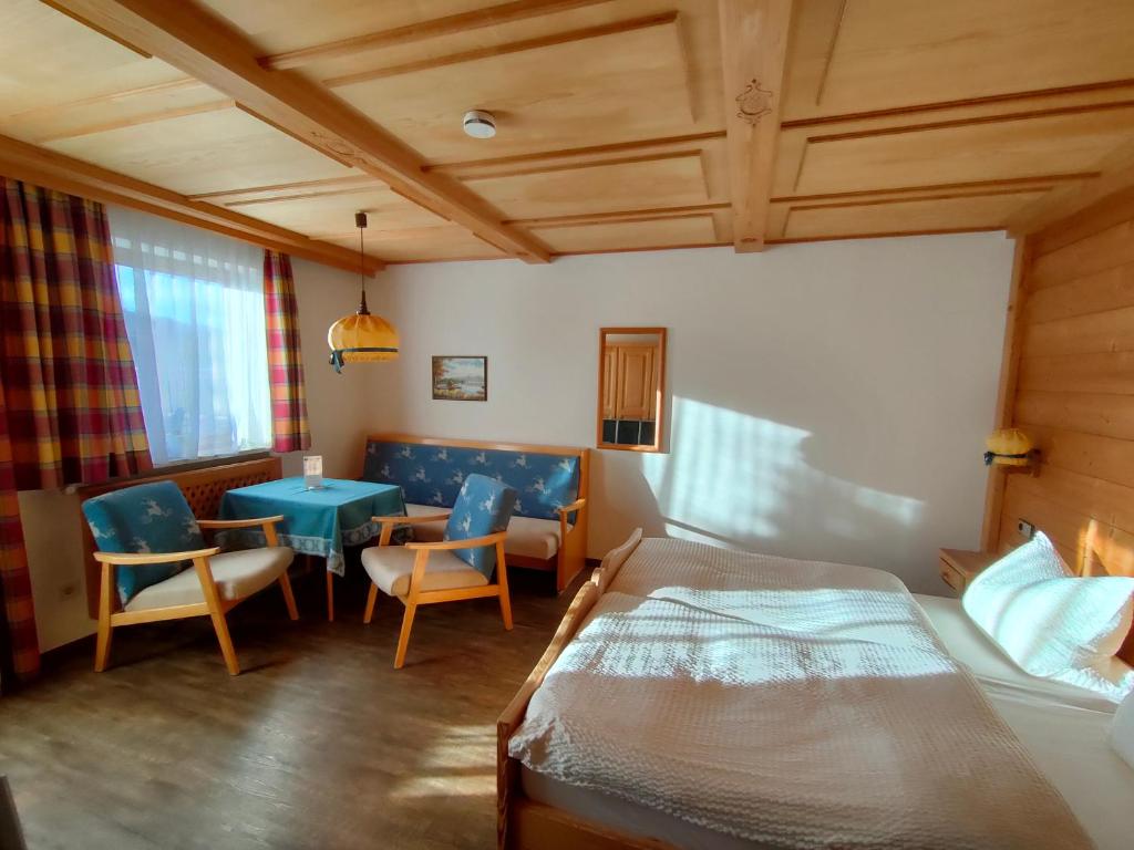 een slaapkamer met een bed en een tafel en stoelen bij Gästehaus Sonnleit`n in Lenggries