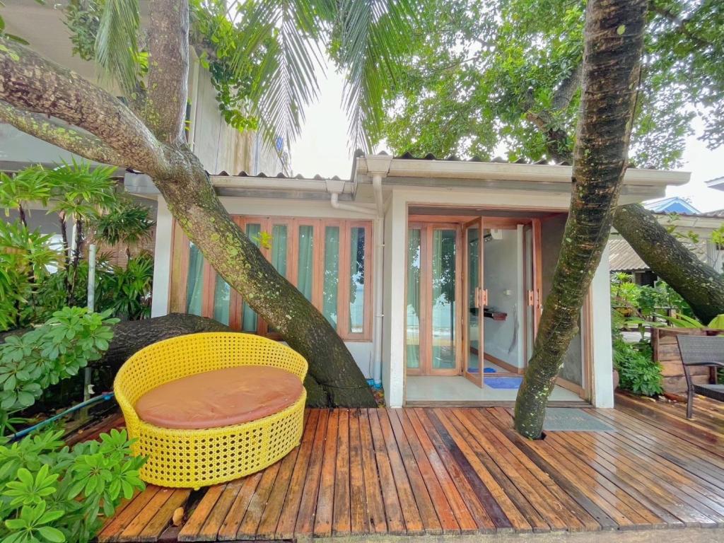 a porch with a yellow chair on a wooden deck at Koh Kwang Beach Resort in Ban Ko Kwang
