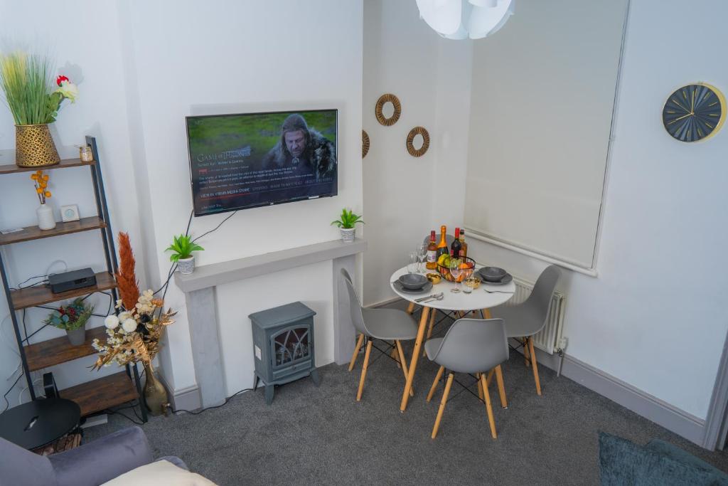 uma sala de estar com uma mesa e uma lareira em The Highfield Villa, 5 bedrooms, Northampton Centre, Sleeps 10 em Kingsthorpe