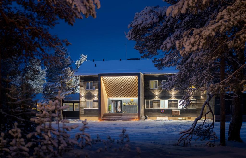 Una casa en la nieve por la noche en Wilderness Hotel Juutua, en Inari
