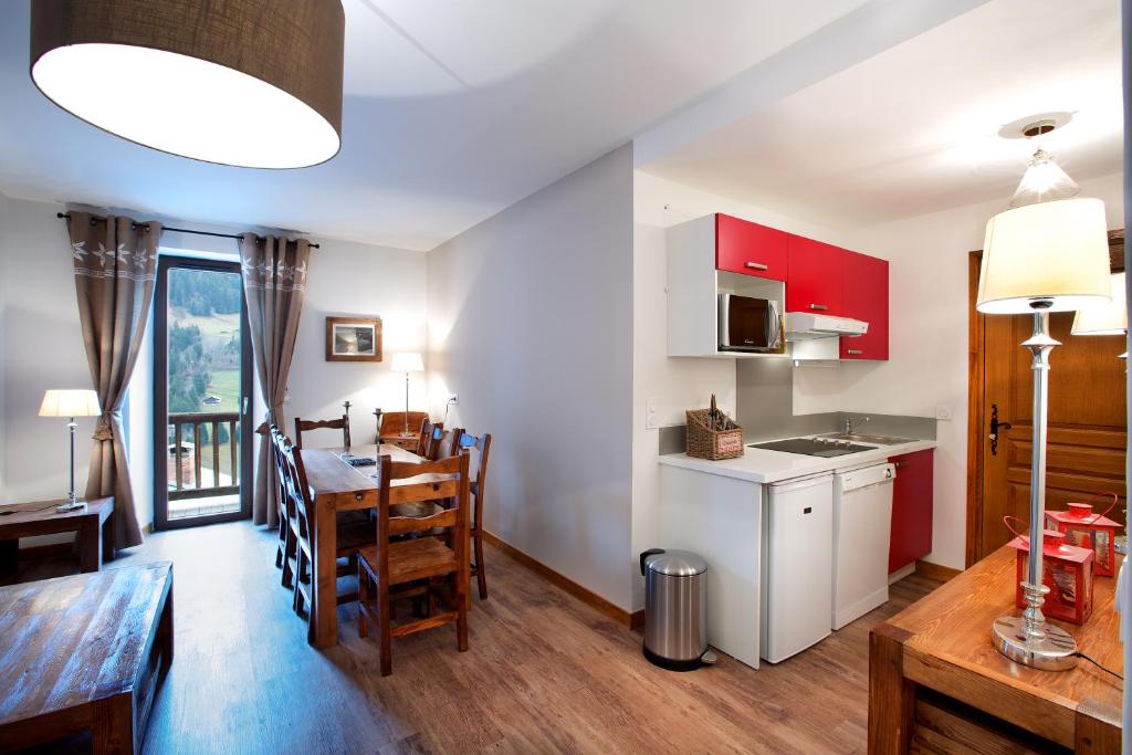 uma cozinha e sala de jantar com uma mesa e uma sala de jantar em LE CHAMOIS LODGE em Hauteluce