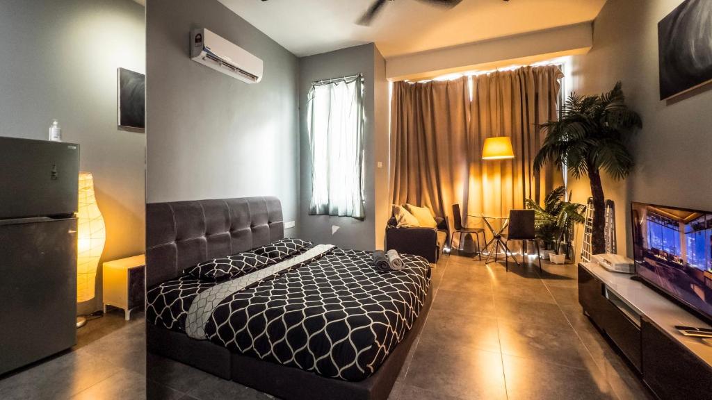 sypialnia z łóżkiem i telewizorem w obiekcie Montana Suites, Empire Damansara w mieście Petaling Jaya