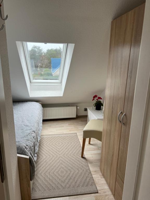 Dormitorio con ventana, cama y puerta en Strandnahe Ferienwohnungen Duhnen inkl Fahrrädern Cuxhaven, en Cuxhaven