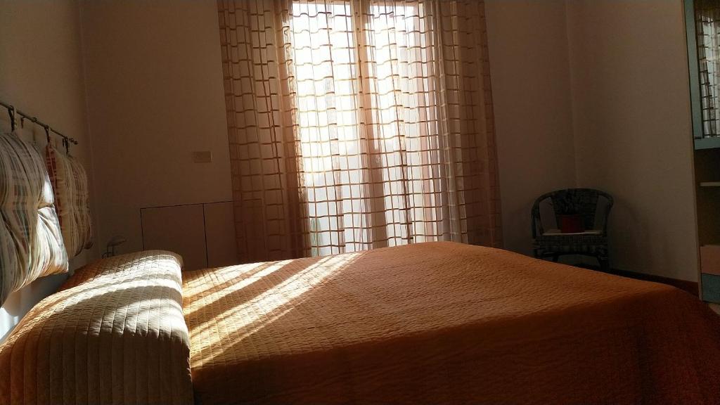 een slaapkamer met een bed en een raam bij Appartamento Panorama in Muravera