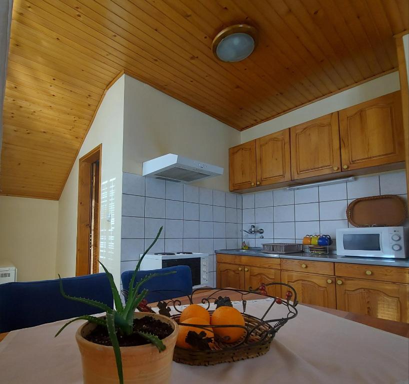 a kitchen with a table with a basket of oranges at Apartmani Milicevic Zlatibor in Zlatibor