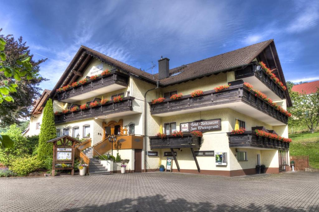 um grande edifício com caixas de flores nas varandas em Zum Wiesengrund em Heimbuchenthal