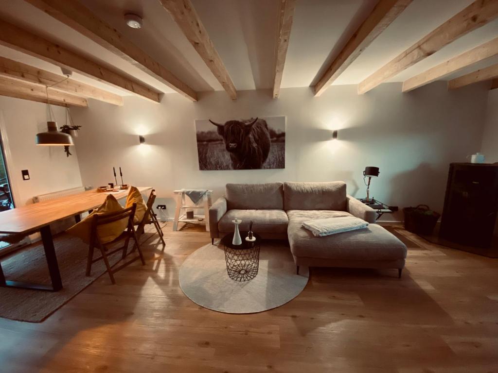 ein Wohnzimmer mit einem Sofa und einem Tisch in der Unterkunft Holzhütte Ole zw. Meer & Wald mit Kamin & Sauna in Behrensdorf