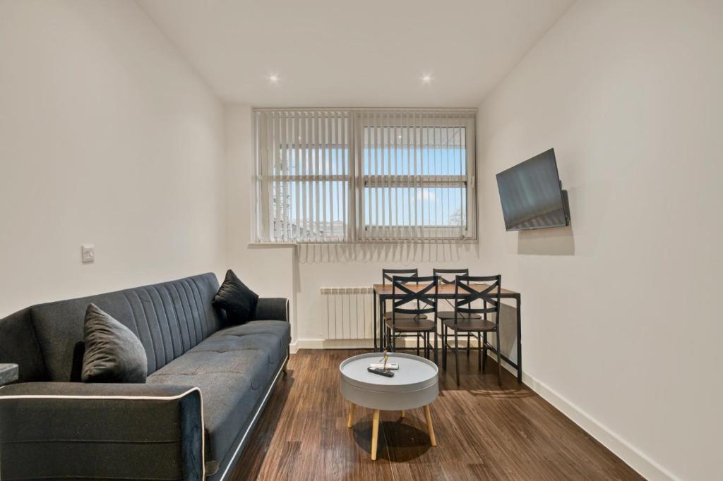 a living room with a couch and a table at Modern 1 Bed by Heathrow Airport in London