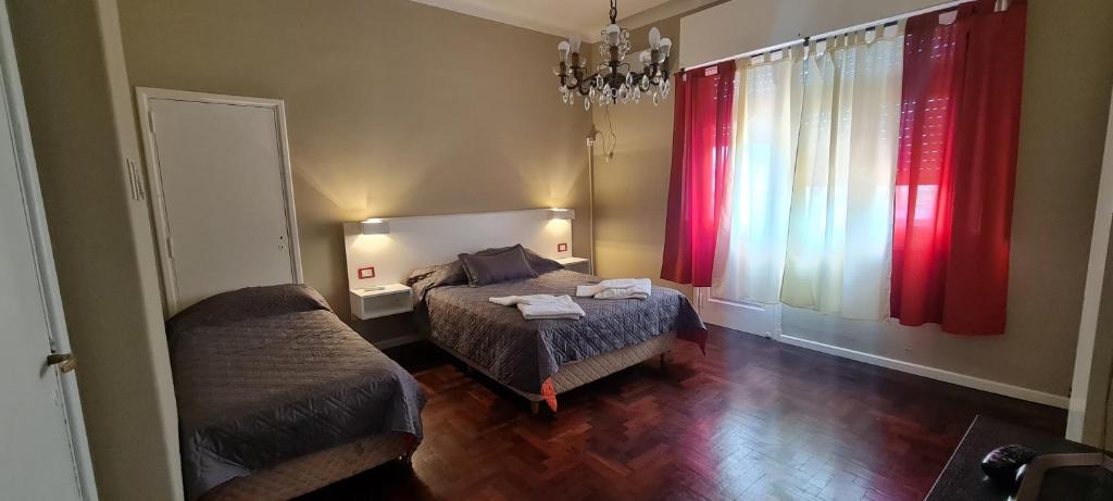 a bedroom with a bed and a window with red curtains at Alojamiento La Floresta, 3 ambientes para 5 personas in Buenos Aires