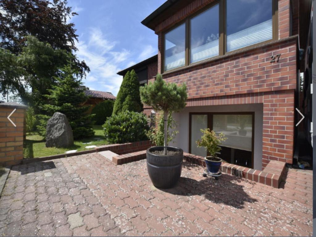 a brick house with two potted plants in front of it at Ferienwohnung in Ostseenähe in Kröpelin