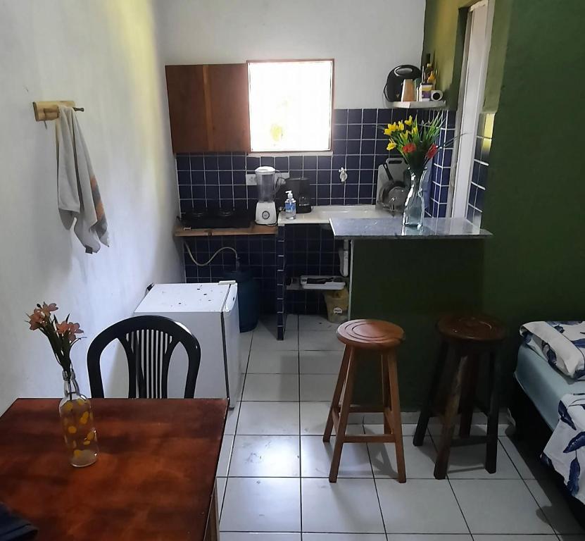 una pequeña cocina con mesa, sillas y fregadero en Eco chalés 1 e 2 en Cabo de Santo Agostinho