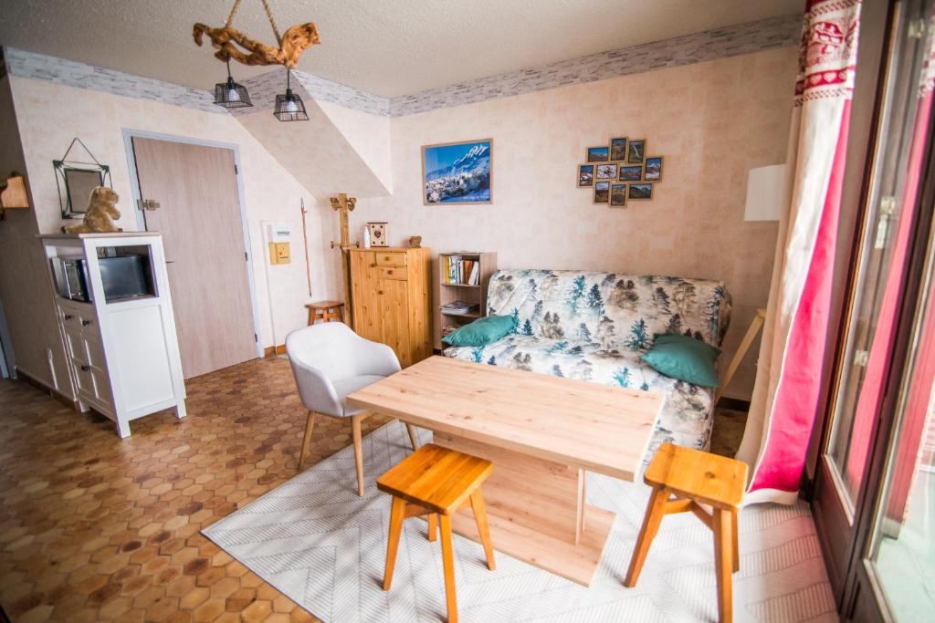 a living room with a couch and a table at Les Campanules in Saint-Léger-les-Mélèzes