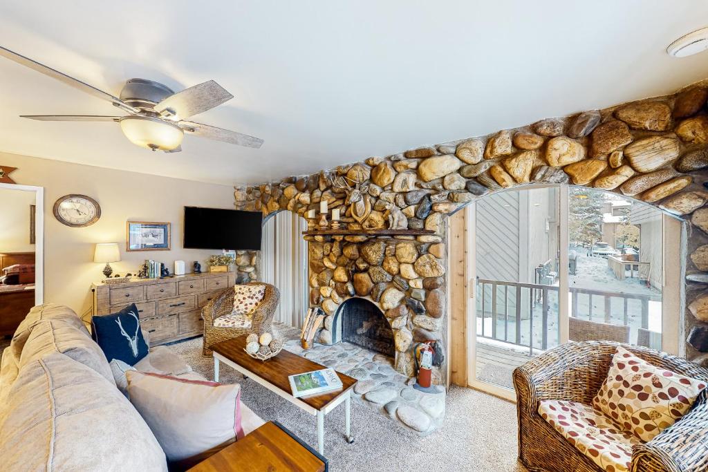 a living room with a stone fireplace and a couch at Sun Valley Hideaway in Ketchum