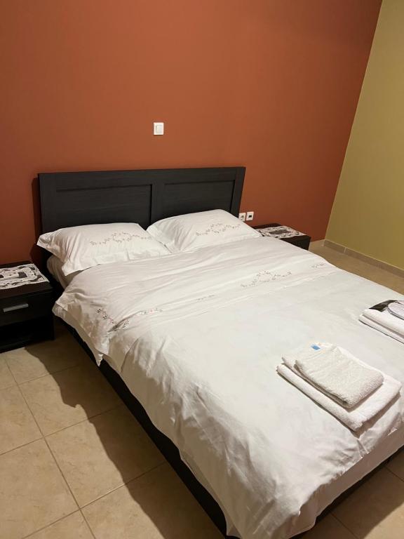 a large bed with white sheets and towels on it at Apartment Mitrou in Loutra Oraias Elenis 