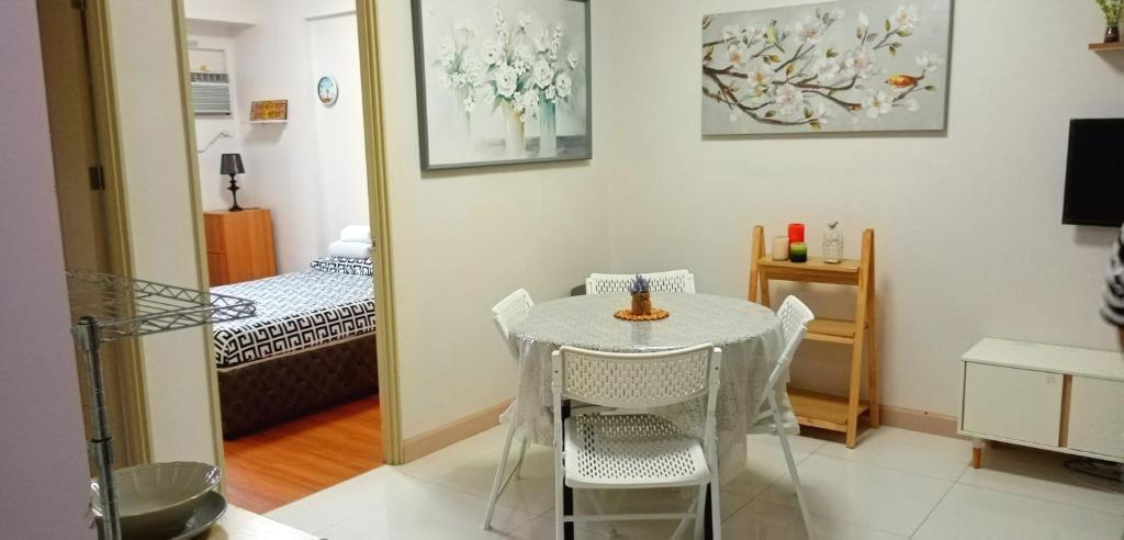a small table and chairs in a room with a bedroom at Darling Vacation Rental Davao City in Davao City