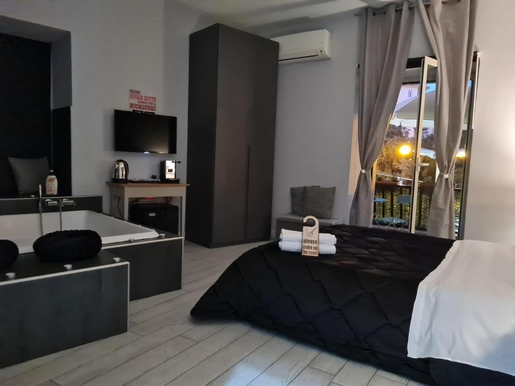 Schlafzimmer mit einem Bett, einer Badewanne und einem Fenster in der Unterkunft ESPOSITO PLAZA- ROOMS & SUITE in Neapel