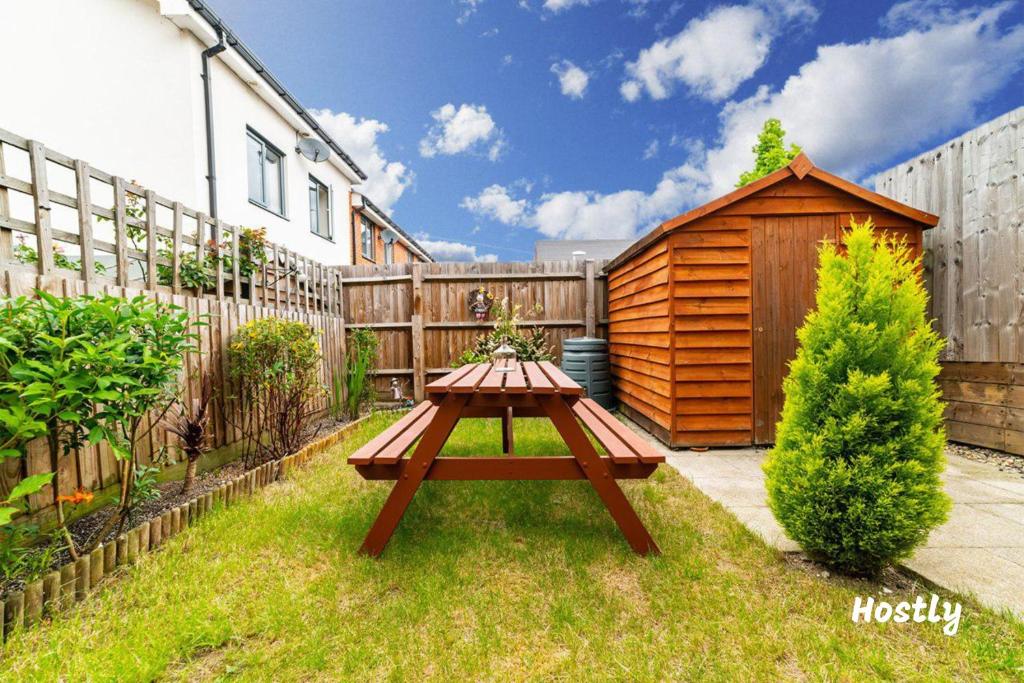 a picnic table in a backyard with a wooden shed at Puffin Way - Comfortable, spacious house with parking in Reading