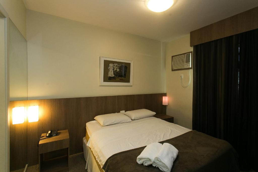 um quarto de hotel com uma cama e duas toalhas em Locking's Barro Preto 4 em Belo Horizonte