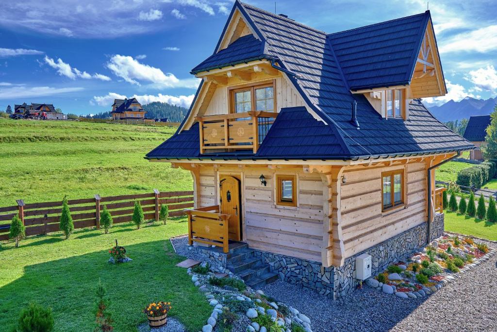 a tiny house with a blue roof at Domy na Spiszu in Czarna Góra