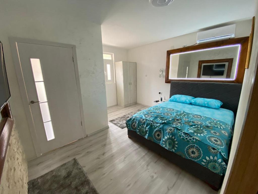 - une chambre avec un lit, un miroir et une porte dans l'établissement Apartman Sedmica, à Danilovgrad
