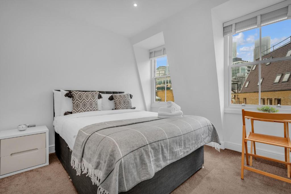 Un dormitorio con una cama grande y una ventana en Two Bedroom Serviced Apartment in Artillery Lane en Londres