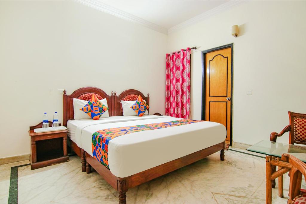 a bedroom with a large bed and a table at FabHotel Singh Suite in Gurgaon