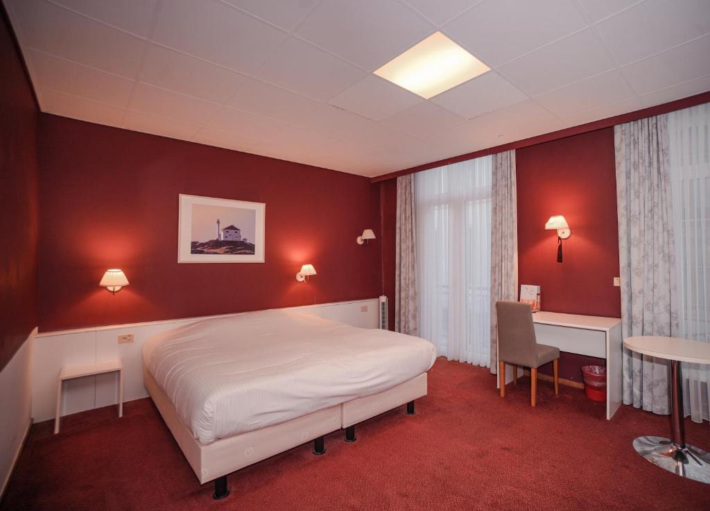 a bedroom with a bed and a desk and a table at Hotel Louisa in Ostend