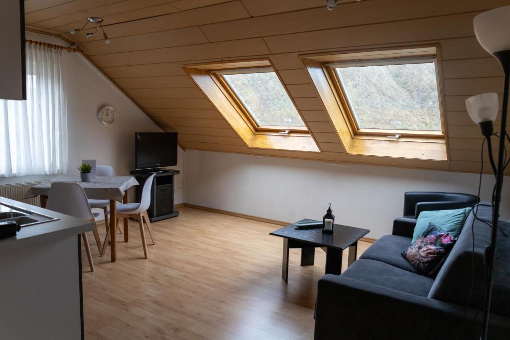 ein Wohnzimmer mit einem Sofa und 2 Fenstern in der Unterkunft Ferienhaus Am Reilsbach in Cochem