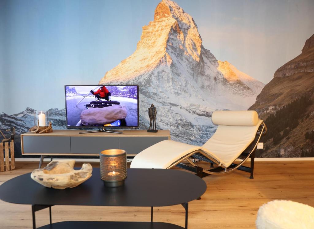 a living room with a mountain mural on the wall at Casa Cervino 45 in Täsch