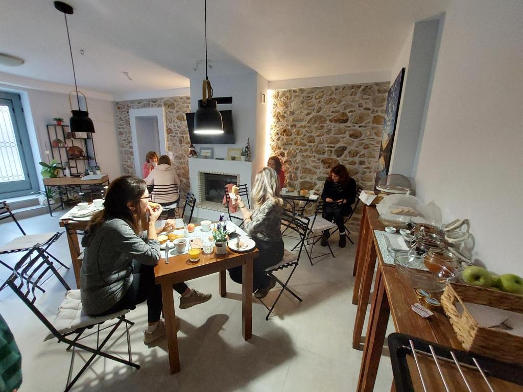 un groupe de personnes assises à une table dans une pièce dans l'établissement Neon, à Larissa