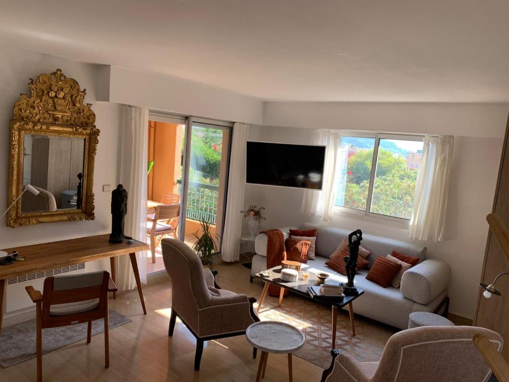 ein Wohnzimmer mit einem Sofa und einem Tisch in der Unterkunft Raffiné appartement in Saint-Jean-Cap-Ferrat