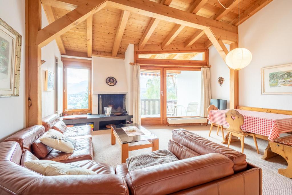 uma sala de estar com um sofá de couro e uma lareira em Casa Pleun em Flims