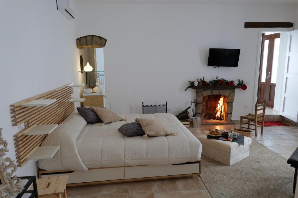 a bedroom with a large bed and a fireplace at La Dimora di Euterpe in Ruviano