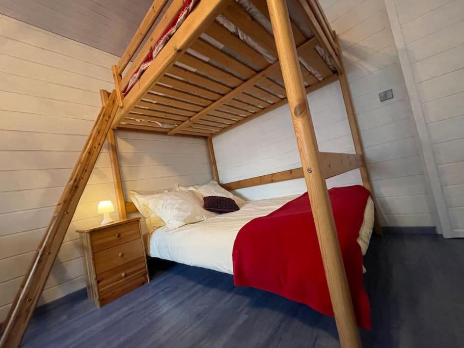 a bedroom with a bunk bed with a red blanket at Joli studio proche Valmorel in Aigueblanche