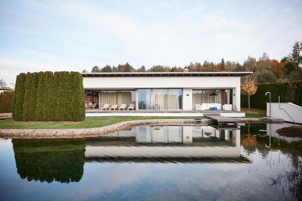 a house with a pond in front of it at Geinberg5 Private Spa Villas in Geinberg