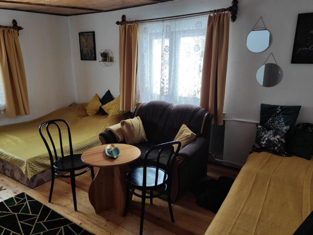 uma sala de estar com um sofá, uma mesa e cadeiras em Home Stay Słotwińska em Krynica Zdrój