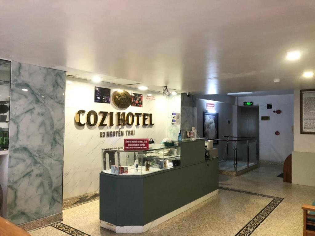 a restaurant with a cola hotel sign on a wall at Cozi Hotel in Hai Phong