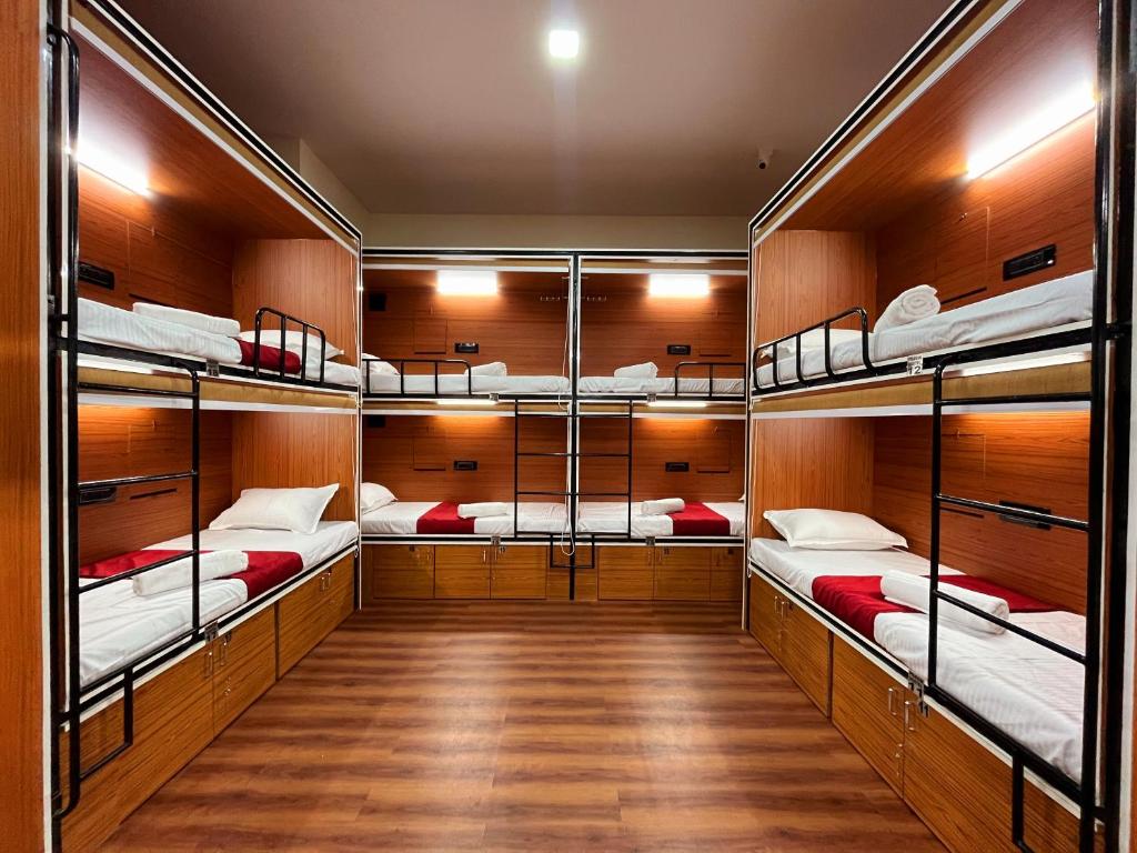a room with four bunk beds on a boat at Rahul Men's AC Dormitory in Navi Mumbai