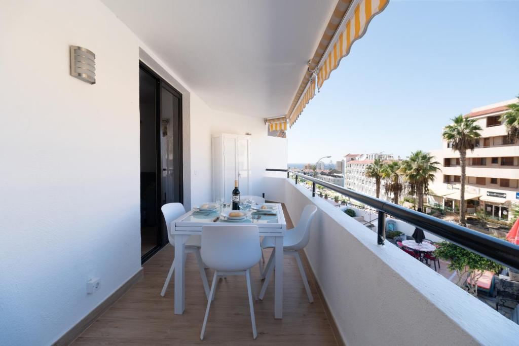 a balcony with a table and chairs and a view of the city at Summerland FREE WIFI in Los Cristianos