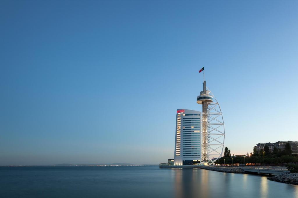 ein hohes Gebäude neben einem Wasserkörper in der Unterkunft MYRIAD by SANA Hotels in Lissabon